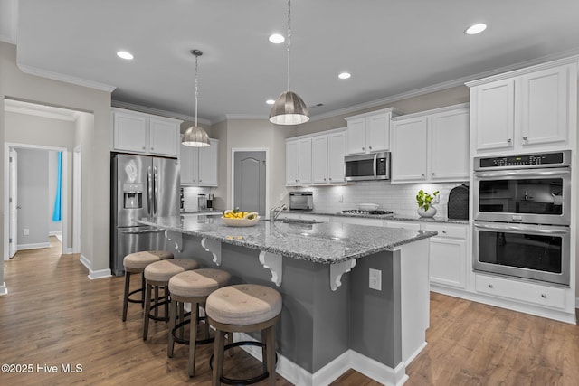 4751 Waves Pointe Pointe, Wilmington, NC 28412 - kitchen featuring stainless steel appliances, a kitchen island with sink, white cabinets, backsplash, and recessed lighting