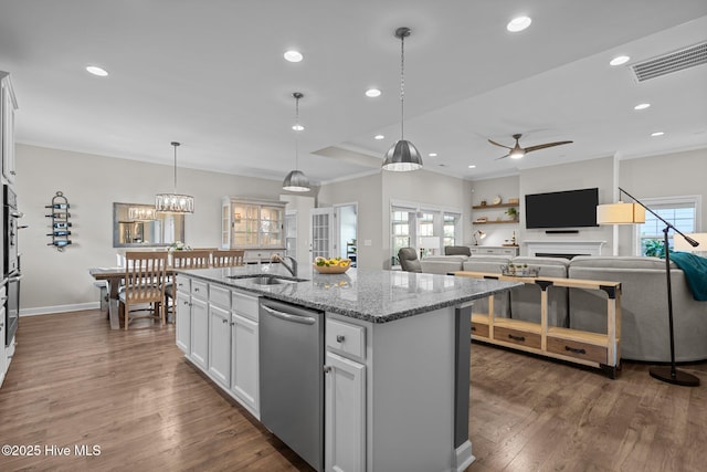 kitchen featuring a sink, dishwasher, ceiling fan, light stone counters, and a kitchen island with sink