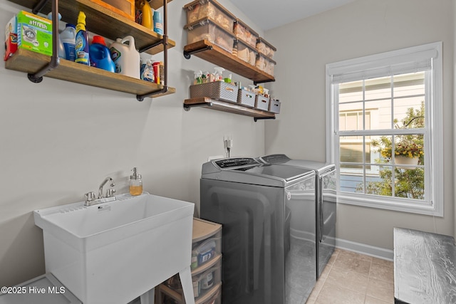 clothes washing area with independent washer and dryer, baseboards, and light tile patterned floors