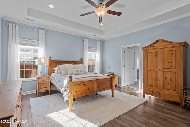 bedroom featuring a raised ceiling, crown molding, wood finished floors, recessed lighting, and a ceiling fan