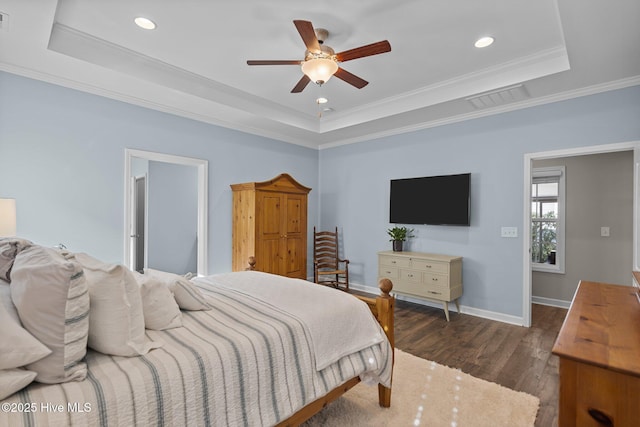 bedroom with a raised ceiling, dark wood-style floors, recessed lighting, ornamental molding, and baseboards