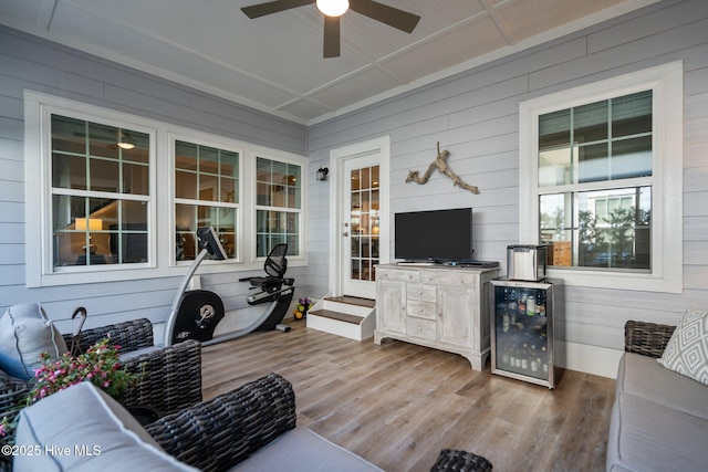 sunroom / solarium featuring beverage cooler, ceiling fan, and vaulted ceiling