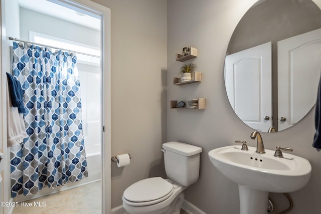 full bath with baseboards, toilet, shower / tub combo, and a sink