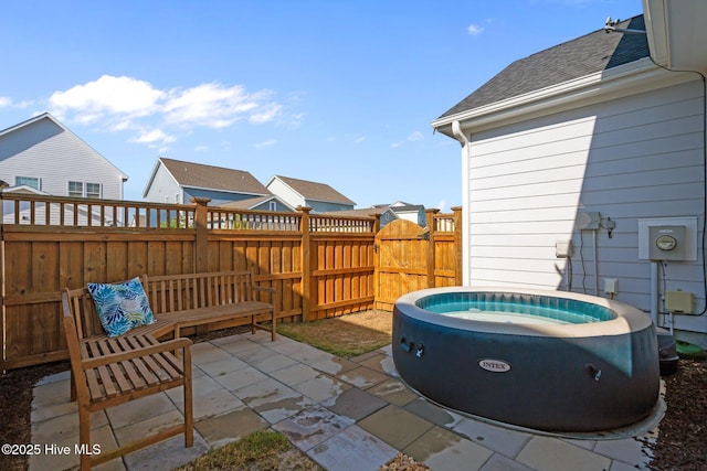 view of patio / terrace with a hot tub and fence