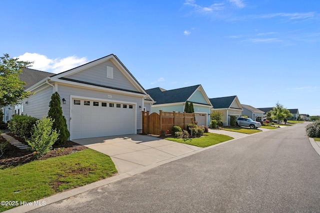 view of front of property with concrete driveway, fence, and a residential view