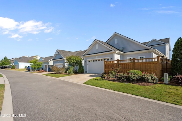 view of front of house featuring driveway, a residential view, and an attached garage