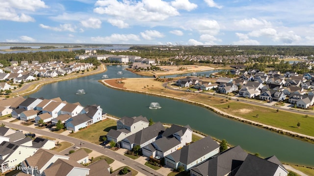 aerial view of property and surrounding area with a large body of water and nearby suburban area