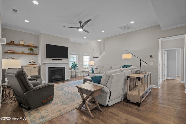 living room featuring ceiling fan, baseboards, ornamental molding, dark wood finished floors, and recessed lighting