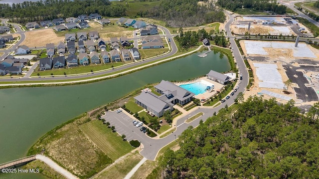 aerial view of property and surrounding area featuring a nearby body of water and a pool area