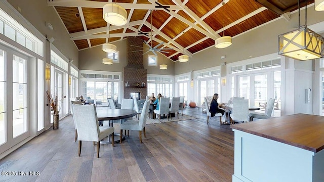 dining room featuring wooden ceiling, wood-type flooring, high vaulted ceiling, beam ceiling, and french doors