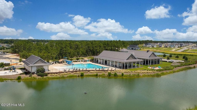 drone / aerial view of a pool area and a nearby body of water