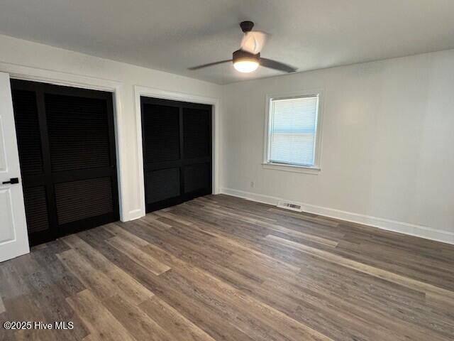 205 Mulberry St, Winton, NC 27986 - unfurnished bedroom featuring wood finished floors, multiple closets, and baseboards