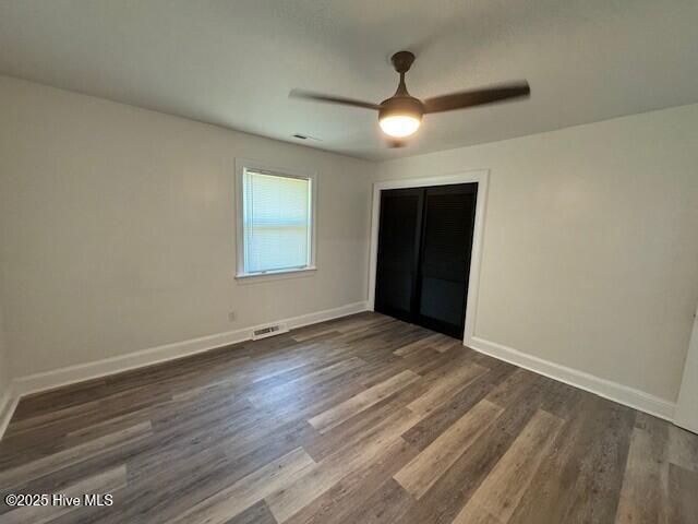 205 Mulberry St, Winton, NC 27986 - unfurnished bedroom featuring a closet, ceiling fan, baseboards, dark wood-style flooring, and visible vents