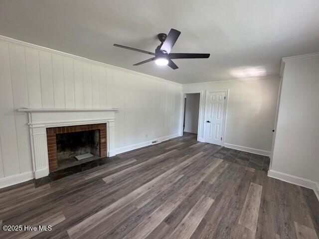 205 Mulberry St, Winton, NC 27986 - unfurnished living room featuring baseboards, a ceiling fan, a brick fireplace, crown molding, and dark wood-type flooring