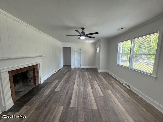 205 Mulberry St, Winton, NC 27986 - unfurnished living room featuring crown molding, wood finished floors, ceiling fan, a brick fireplace, and visible vents