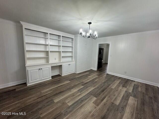 205 Mulberry St, Winton, NC 27986 - unfurnished dining area with dark wood-type flooring, built in study area, a notable chandelier, and crown molding