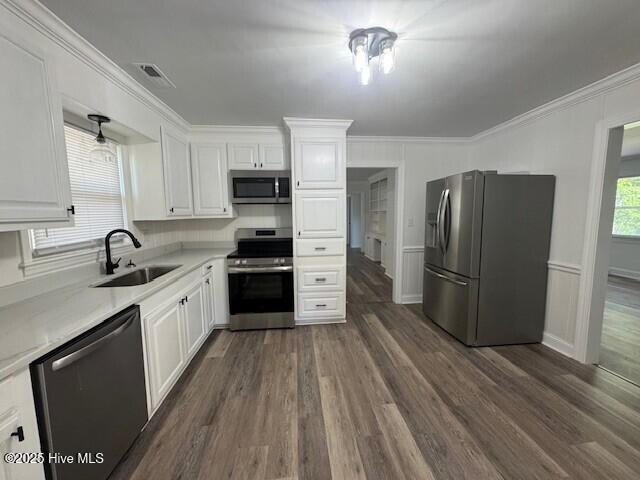 205 Mulberry St, Winton, NC 27986 - kitchen featuring white cabinets, dark wood-style floors, stainless steel appliances, light countertops, and a sink