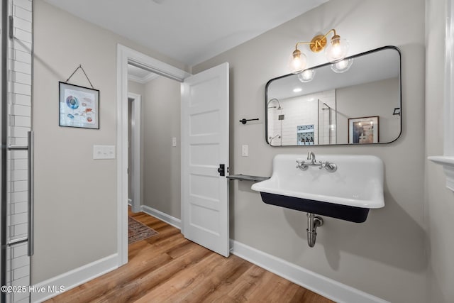 bathroom featuring a sink, baseboards, and wood finished floors
