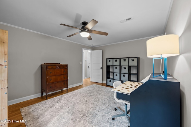 office space with baseboards, ceiling fan, ornamental molding, and wood finished floors