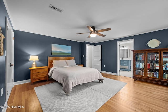 bedroom with baseboards, visible vents, ornamental molding, and wood finished floors