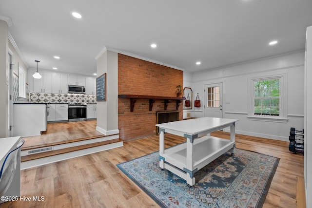 interior space featuring crown molding, recessed lighting, visible vents, and light wood-style floors