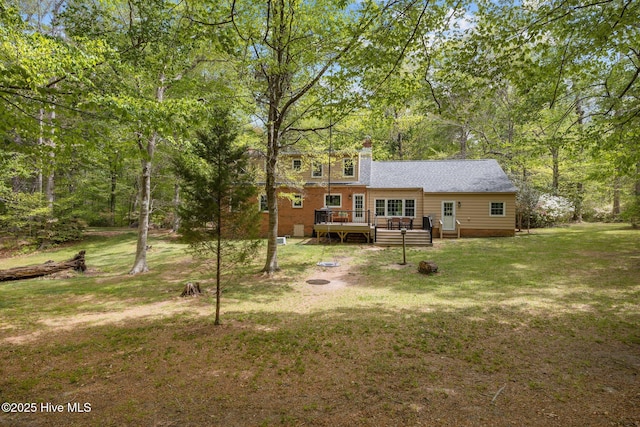 exterior space featuring a lawn, a chimney, and a deck