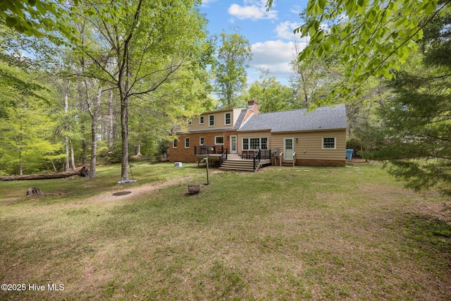 back of house with a lawn, a chimney, a fire pit, and a deck