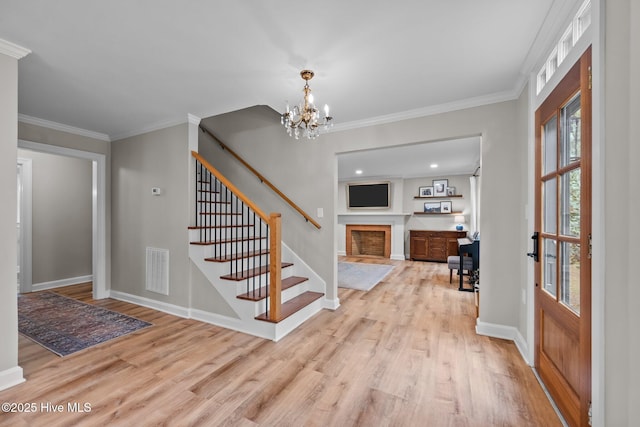 entryway featuring stairs, baseboards, a fireplace with flush hearth, wood finished floors, and visible vents