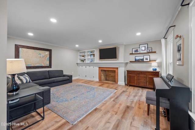 living room featuring recessed lighting, ornamental molding, and light wood finished floors