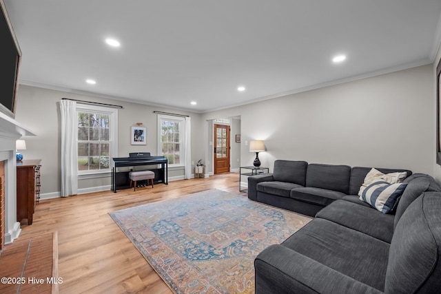 living room featuring a fireplace, light wood-type flooring, baseboards, ornamental molding, and recessed lighting