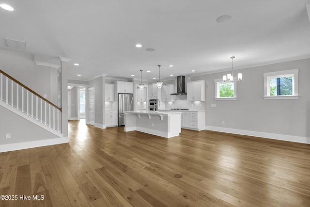 4434 Old Towne St, Wilmington, NC 28412 - unfurnished living room with ornamental molding, light wood-style floors, baseboards, stairs, and recessed lighting