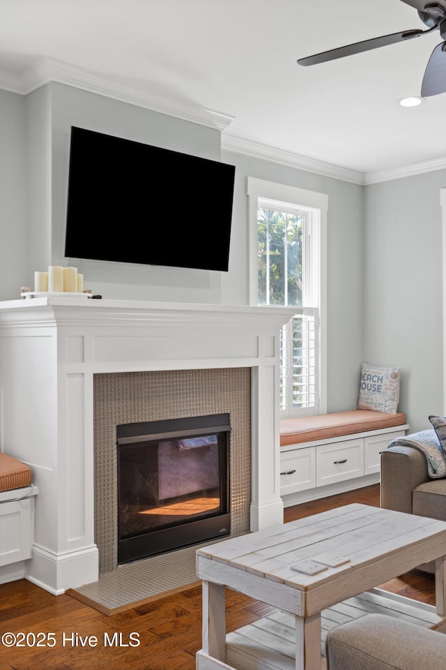 6460 Carrick Bend Trl SW, Ocean Isle Beach, NC 28469 - detailed view of crown molding, a tiled fireplace, wood finished floors, and a ceiling fan