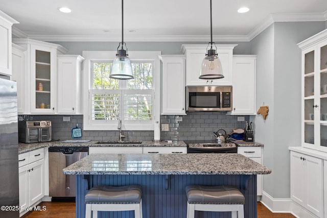 6460 Carrick Bend Trl SW, Ocean Isle Beach, NC 28469 - kitchen featuring appliances with stainless steel finishes, white cabinetry, a kitchen breakfast bar, recessed lighting, and crown molding