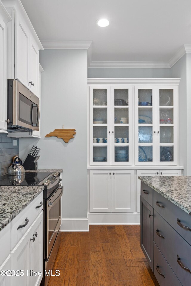 6460 Carrick Bend Trl SW, Ocean Isle Beach, NC 28469 - kitchen with stainless steel appliances, glass insert cabinets, crown molding, white cabinets, and dark wood-type flooring
