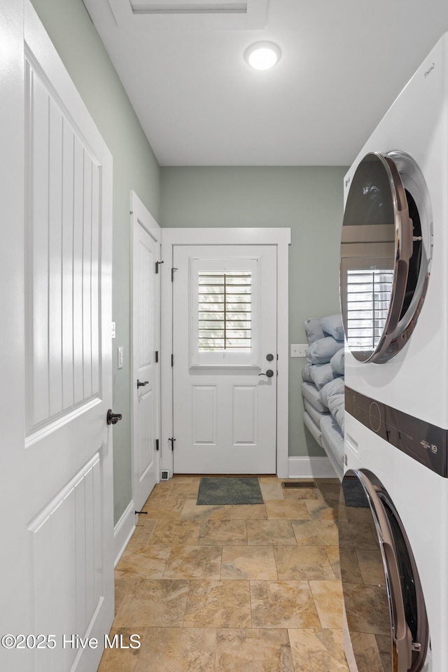 6460 Carrick Bend Trl SW, Ocean Isle Beach, NC 28469 - washroom with stacked washer and clothes dryer and stone finish flooring
