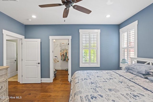 6460 Carrick Bend Trl SW, Ocean Isle Beach, NC 28469 - bedroom with a walk in closet, multiple windows, wood finished floors, a closet, and recessed lighting