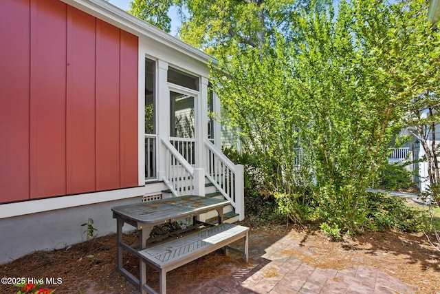 6460 Carrick Bend Trl SW, Ocean Isle Beach, NC 28469 - doorway to property featuring a patio area and board and batten siding
