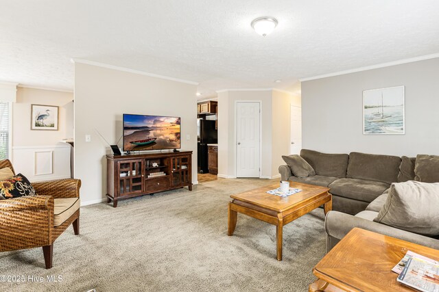 living room with ornamental molding, a textured ceiling, light colored carpet, and baseboards