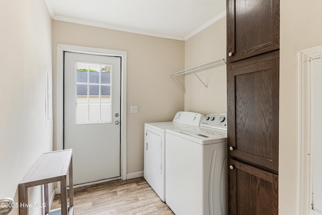 washroom featuring cabinet space, light wood-style flooring, baseboards, ornamental molding, and washer and dryer