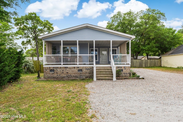 view of front of house with driveway, crawl space, covered porch, and fence