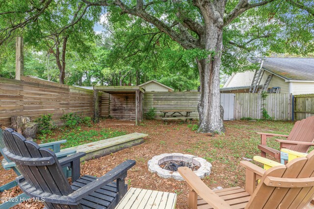 view of yard featuring a fire pit and a fenced backyard
