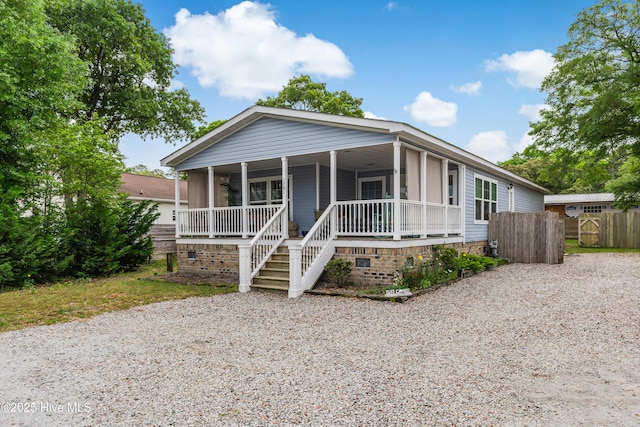 view of front facade with fence, covered porch, and crawl space