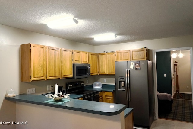 10 Flint Ct Unit 12, Pinehurst, NC 28374 - kitchen with appliances with stainless steel finishes, dark countertops, a peninsula, and a textured ceiling
