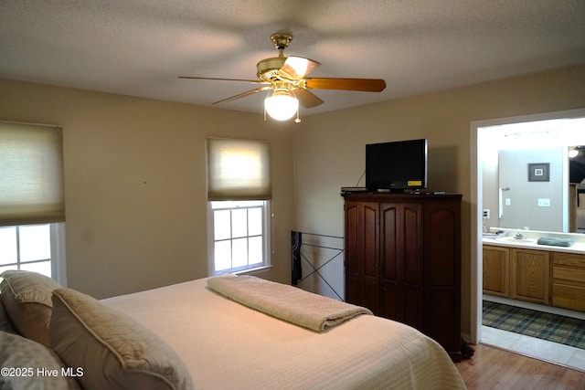 10 Flint Ct Unit 12, Pinehurst, NC 28374 - bedroom with multiple windows, wood finished floors, connected bathroom, and a ceiling fan