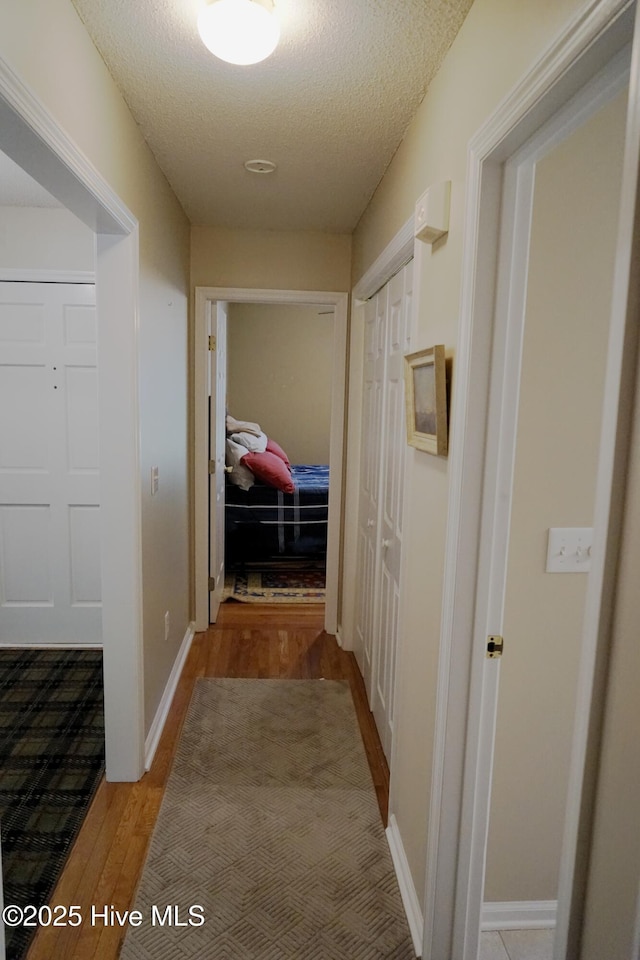 10 Flint Ct Unit 12, Pinehurst, NC 28374 - corridor featuring wood finished floors, a textured ceiling, and baseboards