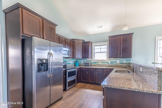 210 Gysgt Dw Boatman Dr Unit 1, North Topsail Beach, NC 28460 - kitchen with appliances with stainless steel finishes, a sink, a peninsula, light stone countertops, and light wood-style floors