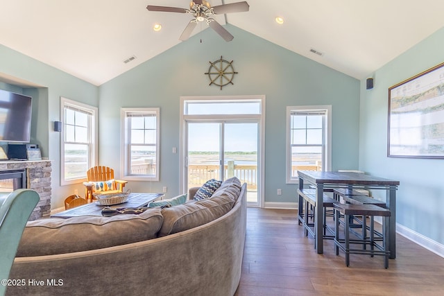 210 Gysgt Dw Boatman Dr Unit 1, North Topsail Beach, NC 28460 - living room featuring wood finished floors, ceiling fan, a stone fireplace, baseboards, and high vaulted ceiling
