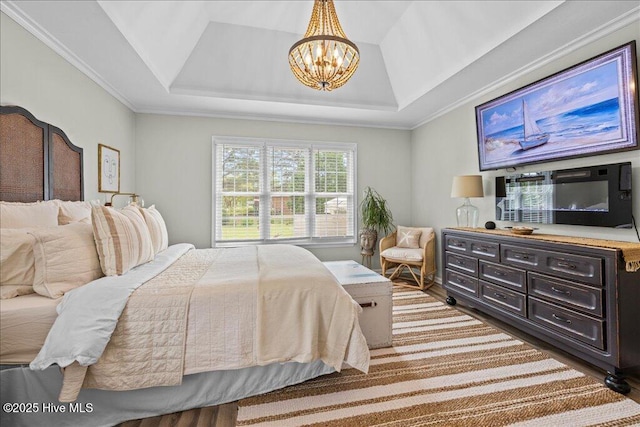 bedroom featuring a chandelier, wood finished floors, a raised ceiling, and crown molding