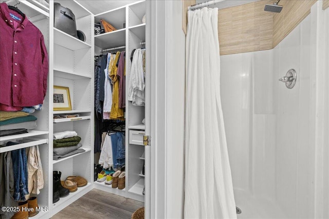 walk in closet with wood finished floors