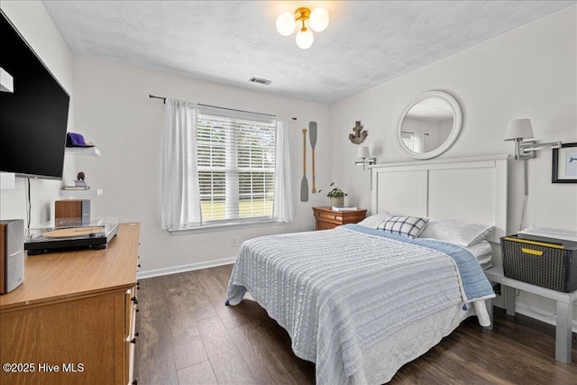 bedroom with dark wood-style floors and baseboards